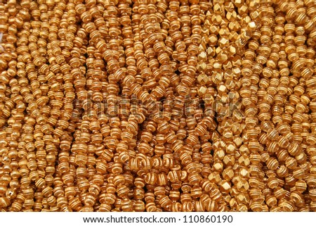 Strings of gold beads for sale at the outdoor craft market in Otavalo, Ecuador