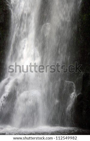 Water cascades into pools at the base of the Peguche waterfall near Otavalo, Ecuador