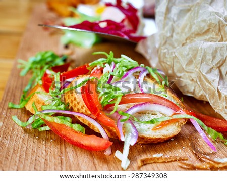 Slice bread sprinkled with herbs, onion and tomato slices