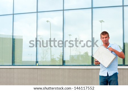 Business man with metal case in front of modern business building.