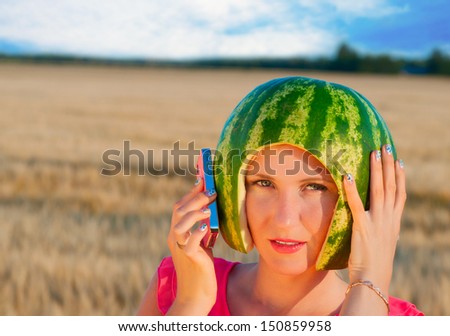 portrait of beautiful sexy young woman model with water-melon on head, woman speaking by phone