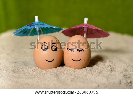 easter funny eggs under umbrella on a sand.