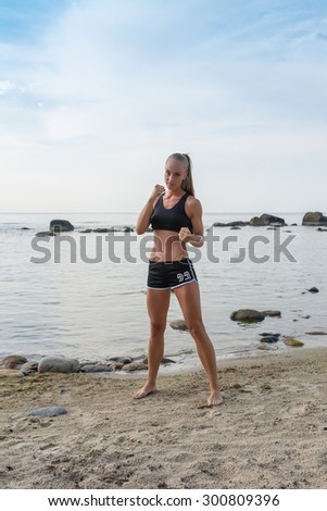 Sport woman in black shorts posing on a beach