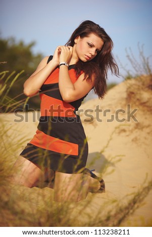 Girl going for a walk in-field and on sand. Beauty and calmness.