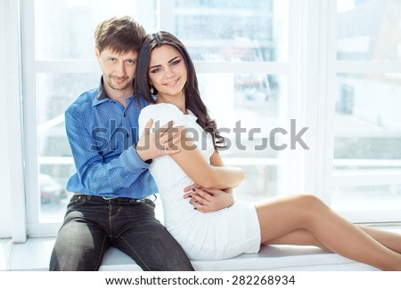 In light studio married couple poses for photograph