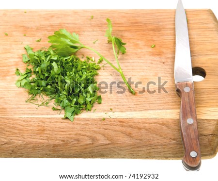Cutting board with green chopped herbs isolated on white background