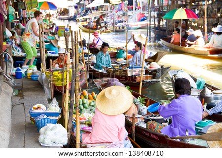 RATCHABURI, THAILAND - MAY 2: Locals travel on rowing boats, selling products at Damnoen Saduak Floating Market on Feb 16, 2008 in Ratchburi, Thailand. The market is one of tourist spots in Thailand
