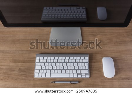 modern computer screen with keyboard and mouse on wooden desktop