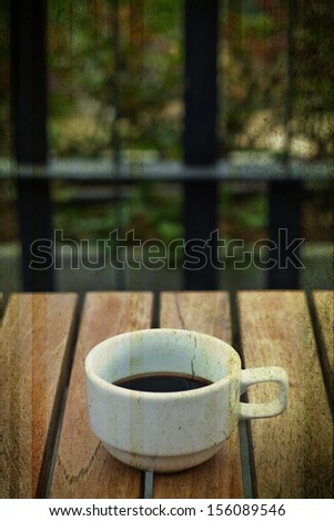 a photo of white cup  with black coffee in garden,texture technical