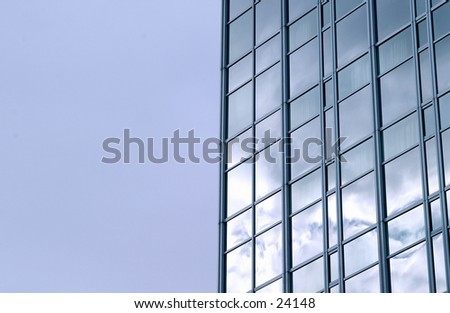A downtown sky scraper reflecting a blue sky and clouds.