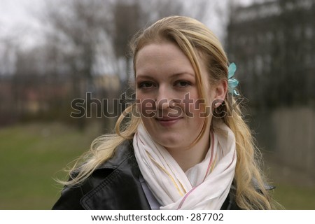 Norwegian woman in a park in oslo smiling into the camera.  A head and shoulders shot.