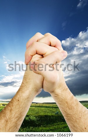 A pair of hands giving thanks on the prairie landscape