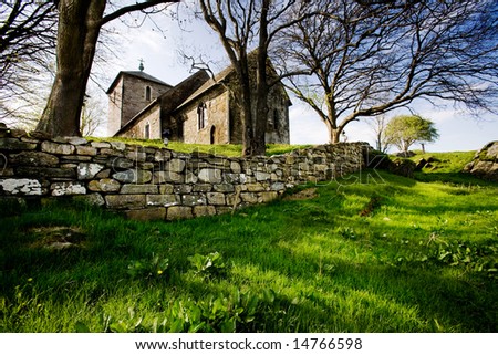 A stone church on a green meadow