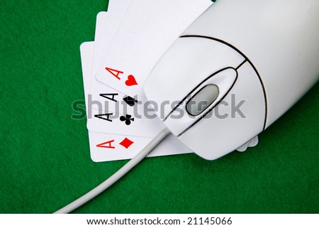 An online gaming concept with computer mouse, four aces and green felt