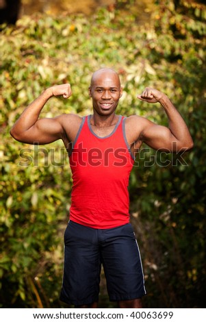 A male flexing his biceps - isolated against a green