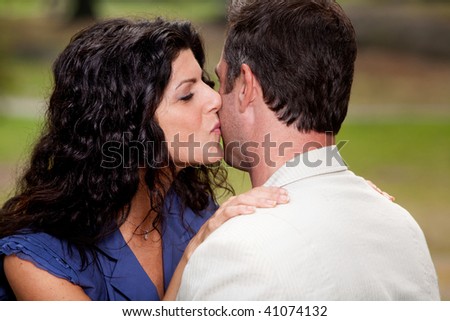 A woman giving a man a kiss on the cheek