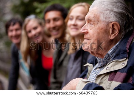 An elderly man telling stories to a group of young people in the forest