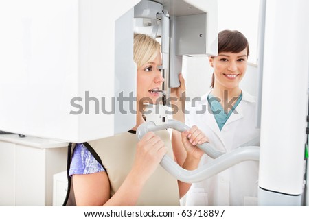 A young dentist taking a panoramic digital X-ray of a patient`s teeth