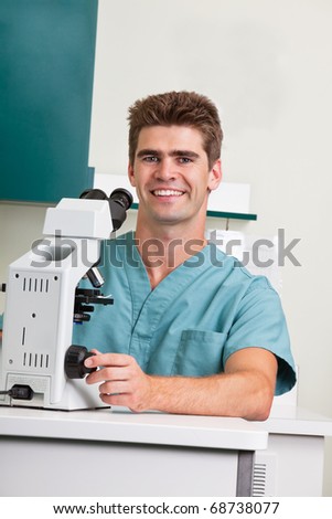 Portrait of happy male doctor with microscope