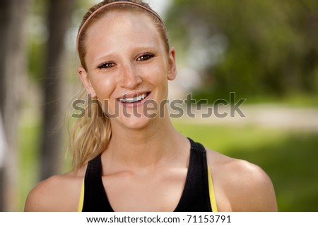 A portrait of a happy female jogger smiling at the camera