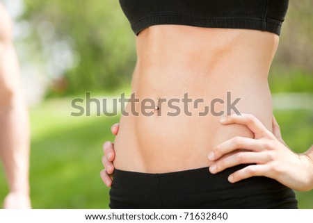 Sexy and fit belly on young woman against blur background
