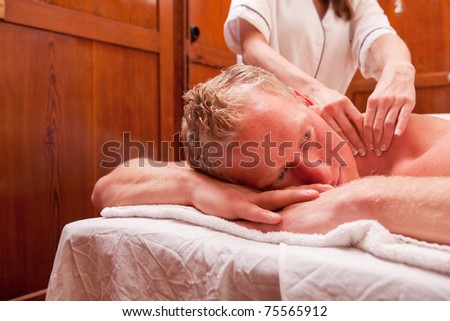 Detail of a man receiving a shoulder massage in an old 1920\'s styled spa