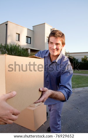 A man passing a moving box to another person