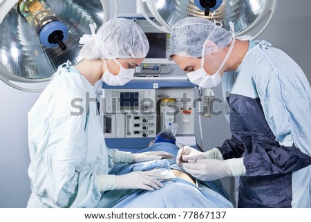 Medical professionals performing an operation on patient in operation theatre