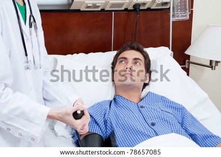 Female doctor checking patient\'s blood pressure in the hospital