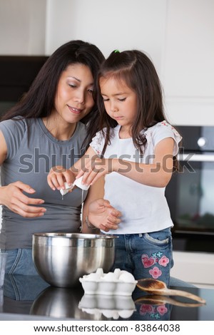 Woman teaching child to prepare dough with healthy ingredients