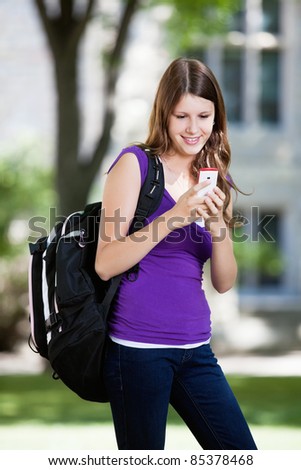 Pretty college girl busy texting on cell