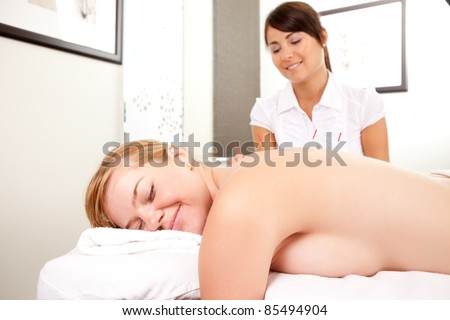 Portrait of a relaxed happy acupuncture patient with needles in the back