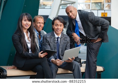 Portrait of smiling business people using electronic gadgets