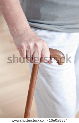 Close-up of elderly woman with walking stick.