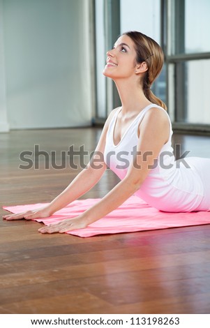 Happy young woman in a cobra pose on mat
