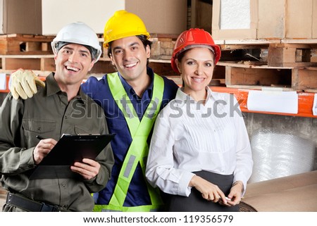 Portrait of young foreman with supervisors smiling together at warehouse