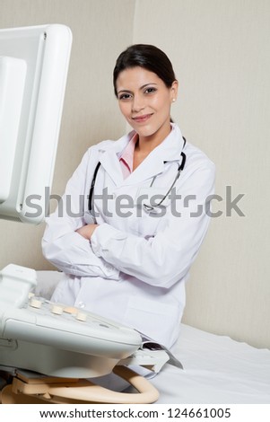 Portrait of an female radiologist smiling while sitting hands folded