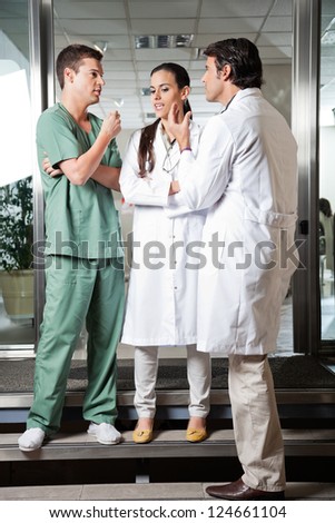 Full length of multiethnic medical professionals interacting with each other while standing on steps