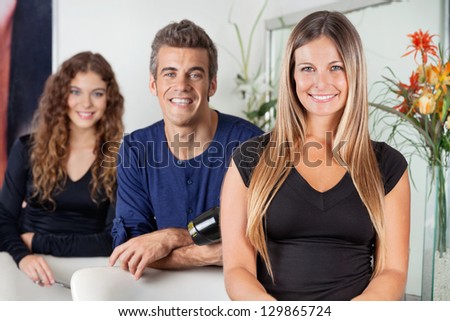 Portrait of happy hairdressers standing together in beauty parlor