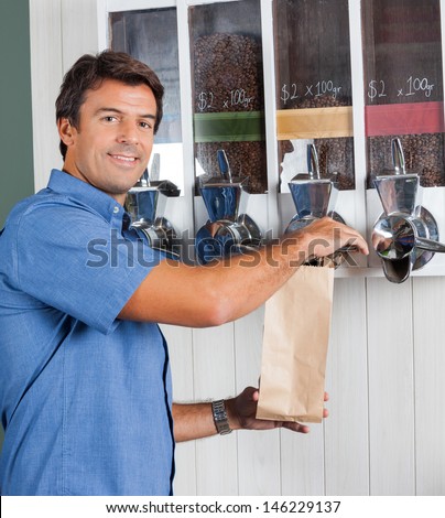 Portrait of mid adult man choosing coffee from vending machine