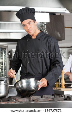 Portrait of confident chef preparing food in commercial kitchen