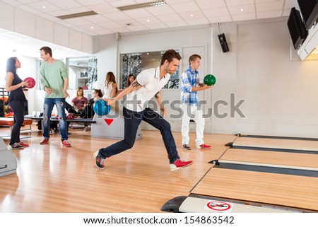 Group of young people playing in bowling alley