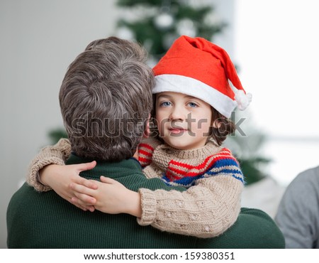 Portrait of son embracing father during Christmas at home