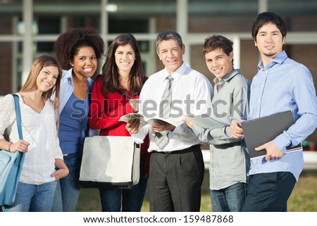 Portrait of confident male professor and students standing on university campus