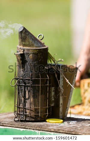 Closeup of bee smoker on crate at farm