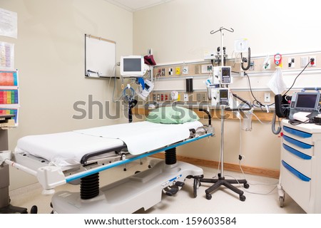 Empty hospital bed with emergency equipment