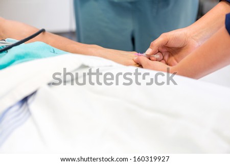 Cropped image of nurse inserting needle in patient\'s nerve at hospital