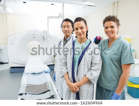 Portrait of medical team with patient smiling in CT scan room