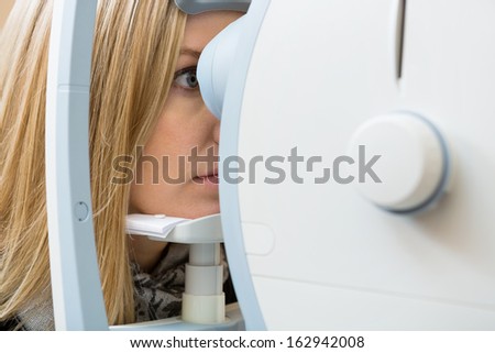 Female patient\'s eyes being examined by digital retina camera