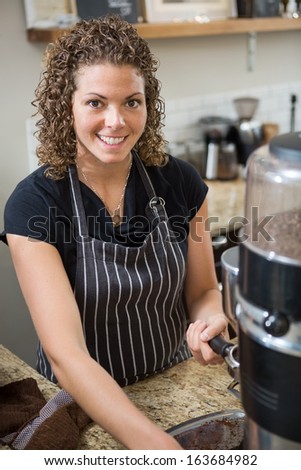 Portrait of happy barista preparing coffee in cafe